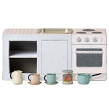 Children's dollshouse play kitchen set with toy sink, stove, and cups on a white background