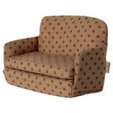 Children's dollshouse chair with brown polka dot pattern on a white background